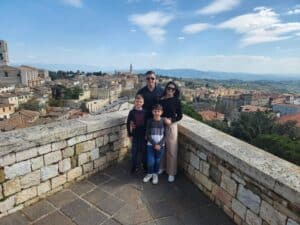 Mum, dad and two kids on a balcony overlooking Tuscany in Italy during Walk for Women's Cancer